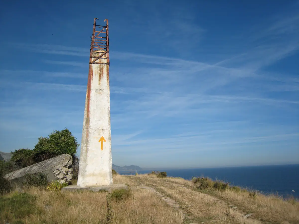 Flecha amarilla del Camino de Santiago pintada en un mojón junto a la costa cantábrica (foto: Sandstein, CC BY-SA 3.0, Wikimedia Commons)